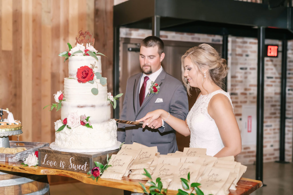 Bride and Groom cutting the four tier white wedding cake