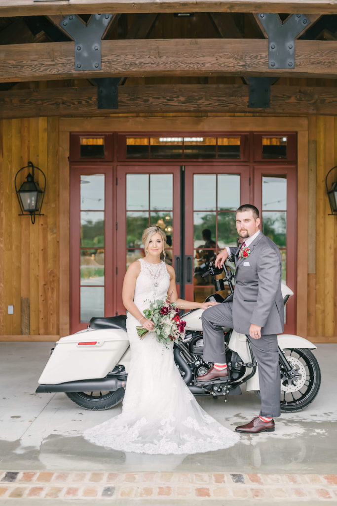 Bride and groom pose with white Harley Davidson motorcycle on the patio of the Weinberg at Wixon Valley