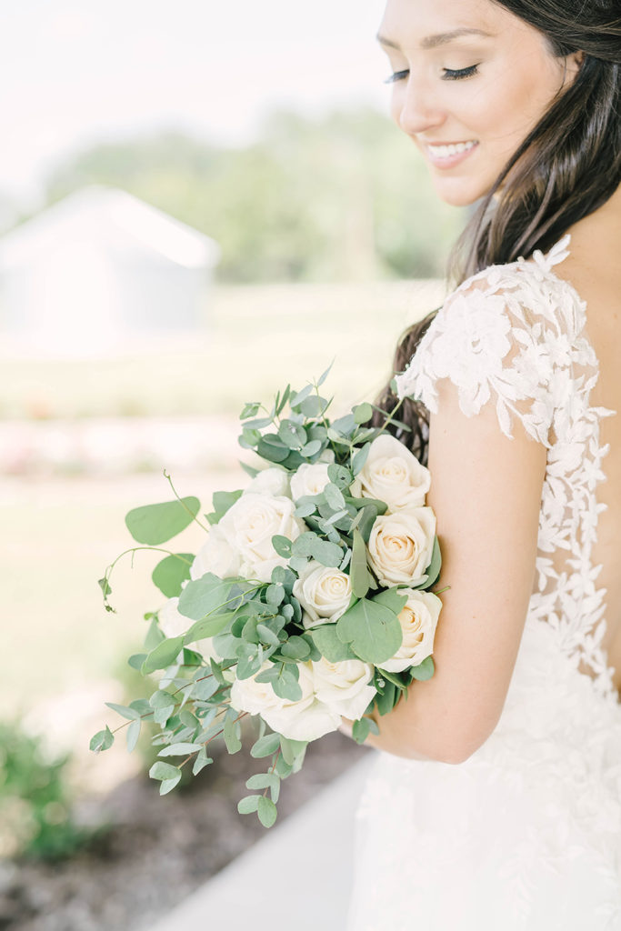 Classic bridal wedding flower bouquet with white and cream flowers and greens with lace back wedding dress by Christina Elliot Photography in Alvin, TX. wedding bouquet inspo white and cream wedding flowers white and cream wedding colors wedding flowers simple wedding flowers classic bridal bouquet brazoria county wedding photographer #houstontexasphotographer #alvintxweddingphotographer #texasweddingphotography #outdoorbridalformals #bridalphotography