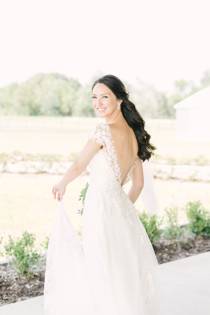 Beautiful bride with low lace back wedding dress and diamond accessories by Christina Elliot Photography in Alvin, TX. still waters ranch event venue bridal wedding photography wedding dress inspo wedding accessories diamonds for wedding jewelry ideas for wedding hair inspo for bridals brazoria county houston texas wedding photographer #houstontexasphotographer #alvintxweddingphotographer #texasweddingphotography #outdoorbridalformals #bridalphotography