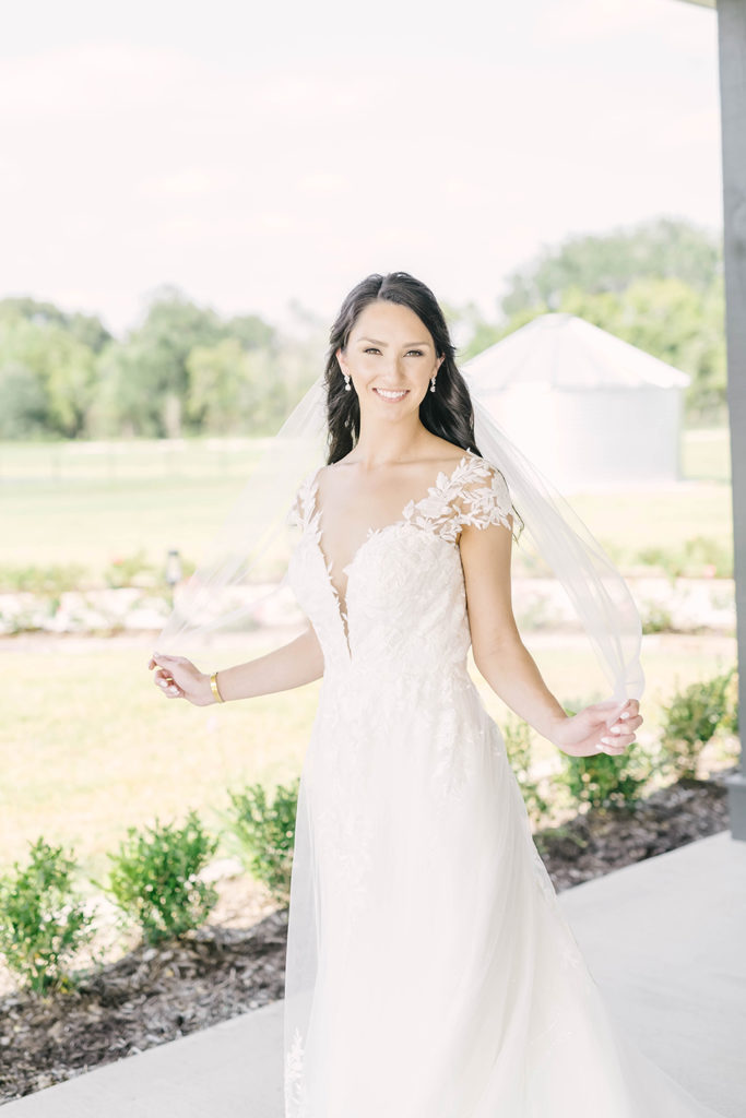 Beautiful bride with a heart neckline wedding dress with lace and sheer accents by Christina Elliot Photography in Houston, TX. alvin tx brazoria county still waters ranch event venue wedding dress inspo heart neckline wedding dresses sheer wedding dresses lace wedding dresses veils with wedding dresses vneck wedding dresses cap sleeve #houstontexasphotographer #alvintxweddingphotographer #texasweddingphotography #outdoorbridalformals #bridalphotography