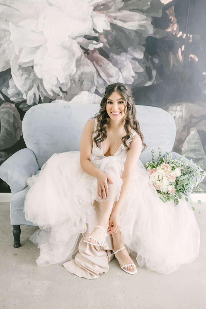 Gorgeous bride with cream lace wedding dress and thin strap white shoes with a pink and white and green bridal bouquet. brides dress inspo wedding dress ideas cream wedding dress wedding shoes ideas simple wedding shoes bridal bouquet inspo beautiful wedding flowers wedding hair inspo greenhouse wedding houston wedding photographer #houstontexasphotographer #houstonweddingphotographer #texasweddingphotography #greenhousewedding #outdoorweddinginspo