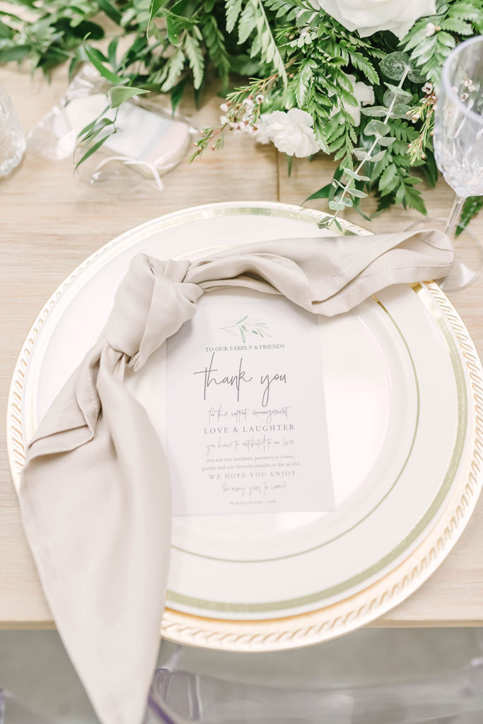 Simple white elegant place setting for wedding dinner with cream napkins and cursive lettering menu on plate by Christina Elliot Photography in Houston, TX. wedding dinner place settings colors for wedding dinner plate settings for wedding dinner simple wedding dinner wedding dinner menu inspo houston texas wedding photographer greenhouse #houstontexasphotographer #houstonweddingphotographer #texasweddingphotography #greenhousewedding #outdoorweddinginspo