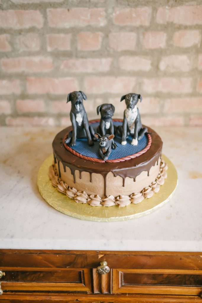 Darling custom cake designed for the bride and groom’s four dogs, complete with dog figurines as cake toppers. Custom dog cake fur babies dog wedding cake ideas incorporating furry friends into your wedding Christina Elliot Photography puppy cake at the wedding