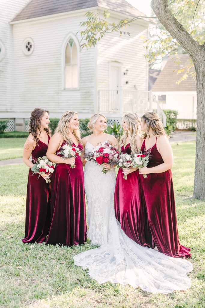 The bride and her bridesmaids smile and laugh with one another before the wedding ceremony at Butler’s Courtyard. Christina Elliot Houston wedding photographer Butler’s Courtyard wedding venue summer weddings bridesmaids dresses wedding color inspo