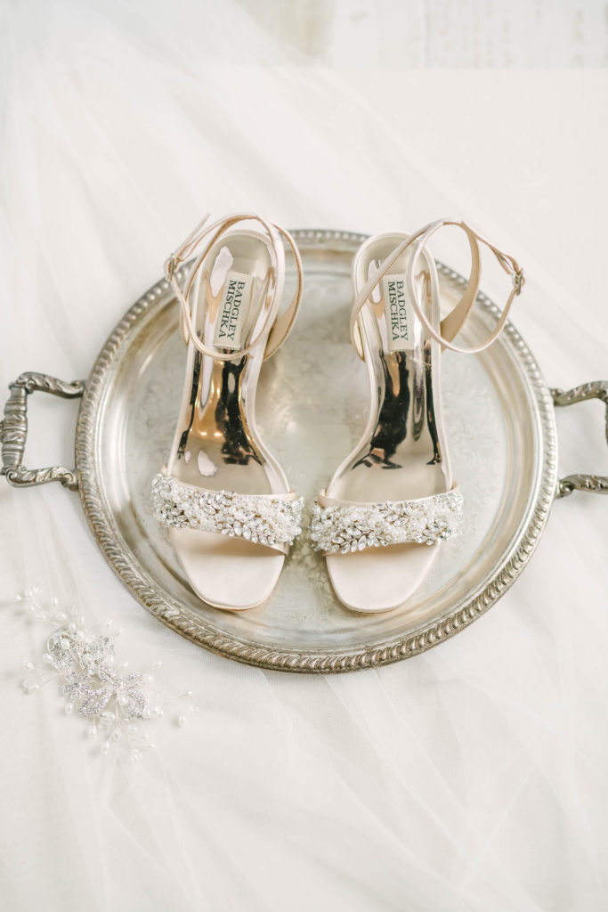 These stunning bride shoes were a detail captured by Christina Elliot Photography at Still Waters Ranch in Houston, Texas. Diamond bride shoes silver platter white table cloth bridal inspo country ranch wedding barn style alvin texas photographer houston #houstonweddingphotographer #texasphotographer #weddingdaydetails #barnstylewedding #stillwatersranch #alvintexasphotographer #weddingday #brideandgroom #texanwedding #htxwedding #countrywedding