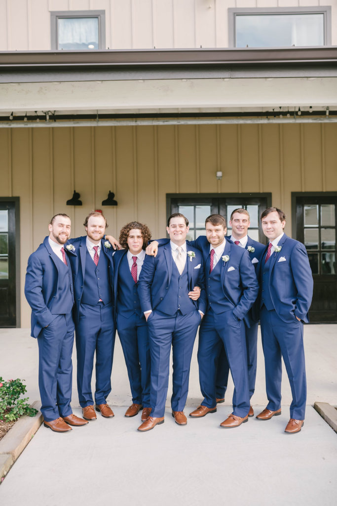The groom and his groomsmen before the ceremony at Still Waters Ranch in Alvin, Texas with Christina Elliot Photography. Navy blue wedding suits inspo maroon ties groom groomsmen country wedding barn outdoor marriage houston texas wedding photographer #houstonweddingphotographer #texasphotographer #weddingdaydetails #barnstylewedding #stillwatersranch #alvintexasphotographer #weddingday #brideandgroom #texanwedding #htxwedding #countrywedding