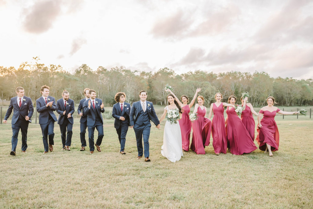 A celebretory picture for the bride and groom on their wedding day in Houston, Texas with Christina Elliot Photography. Celebrate wedding bridesmaids and groomsmen bride and groom pink dress navy blue suit wedding outfit inspo houstin wedding photographer #houstonweddingphotographer #texasphotographer #weddingdaydetails #barnstylewedding #stillwatersranch #alvintexasphotographer #weddingday #brideandgroom #texanwedding #htxwedding #countrywedding