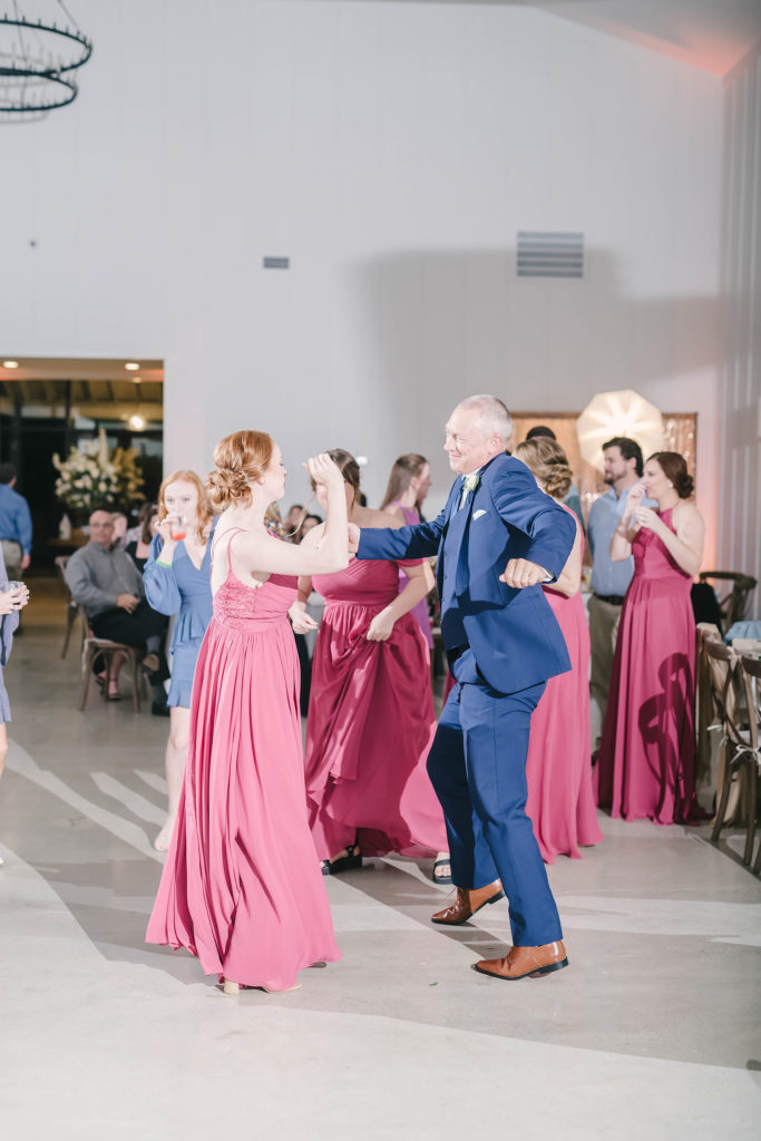 Christina Elliot Photography captures this candid dancing scene at a barn style wedding in Houstin, Texas. Wedding dance first dance bridesmaid groomsmen maroon pink bridesmaid dress navy blue suit texas wedding Houston wedding inspiriation still waters ranch barn #houstonweddingphotographer #texasphotographer #weddingdaydetails #barnstylewedding #stillwatersranch #alvintexasphotographer #weddingday #brideandgroom #texanwedding #htxwedding #countrywedding