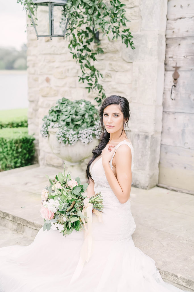 Bridal portrait of stunning bride in lace dress on the steps of the chapel at the Clubs at Houston Oaks