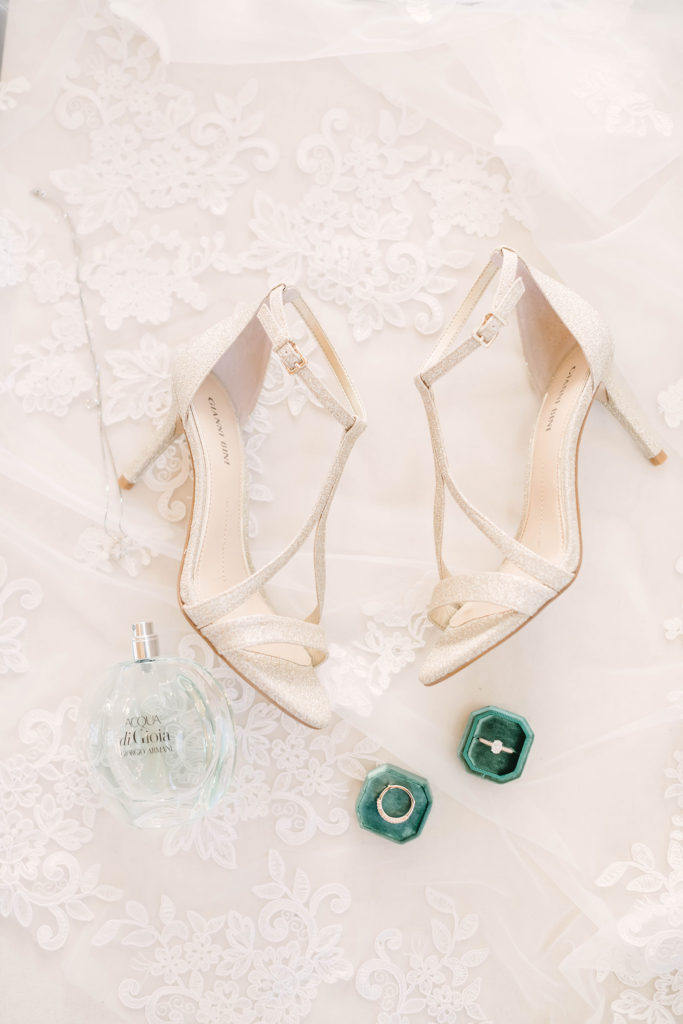 Gold bridal shoes styled on top of a white lace veil.