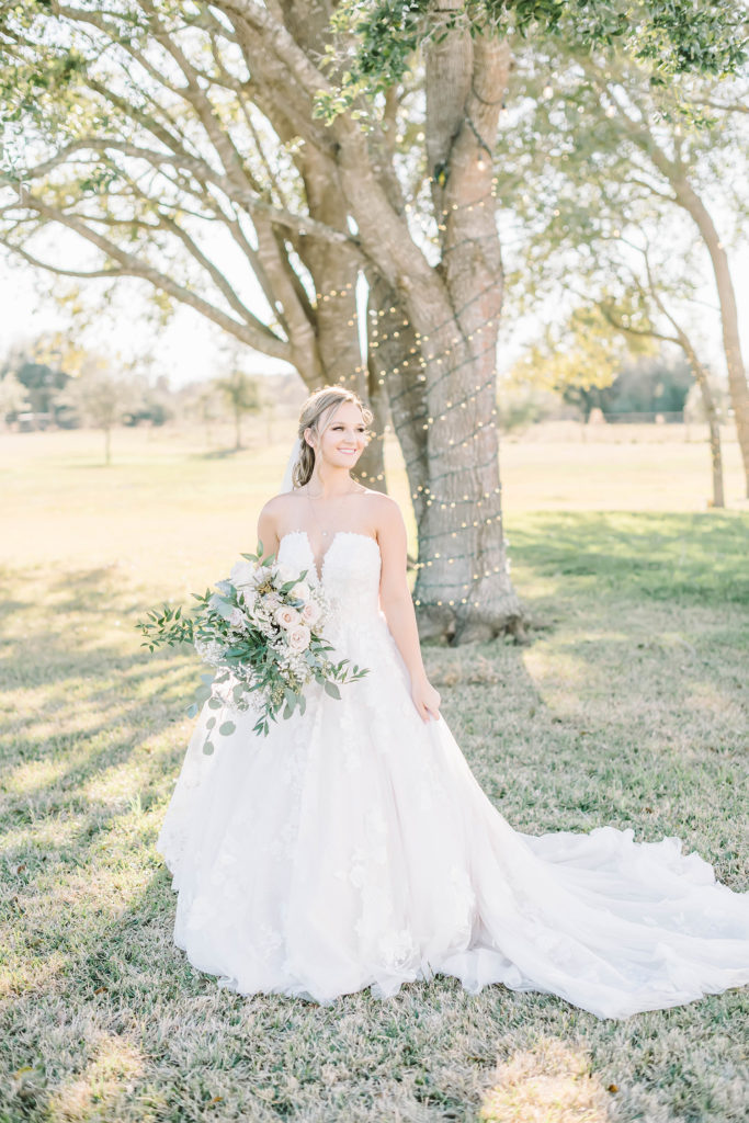 Beautiful bride in her plunging white wedding gown during her bridal portrait session at the Barn at Willowynn.