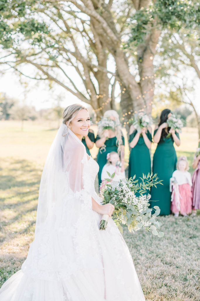 Bride turns over her shoulder to smile before the first look with her bridesmaids