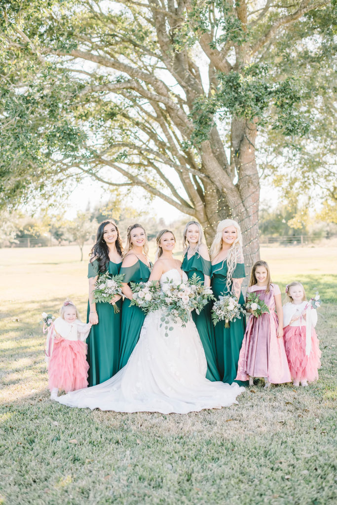 Lovely bridal party in emerald green bridesmaid gown and blush pink junior bridesmaid dress