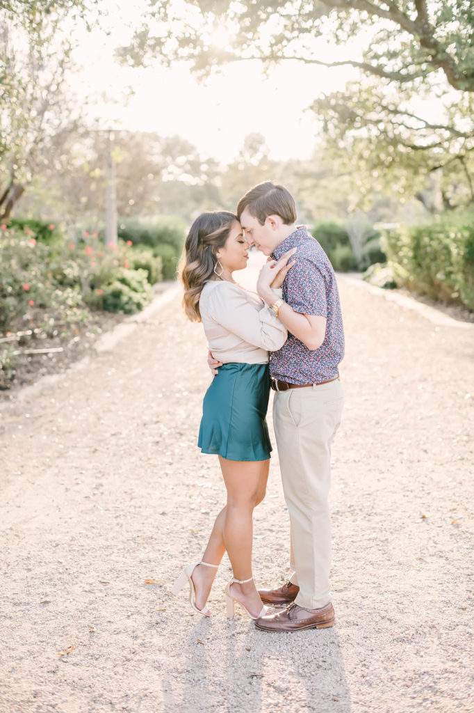 A happy couple poses in love at their stunning engagement session in Houston, Texas with Christina Elliot Photography. In love she said yes engagement session Christina elliot photos pose inspo garden setting flowers montgomery texas photography dirt path semi formal attire inspiration #houstonweddingphotographer #engagementpics #houstonphotographer #engagementphotos #shesaidyes #texasphotographer #photoinspiration #weddingphotography #houstonphotographer