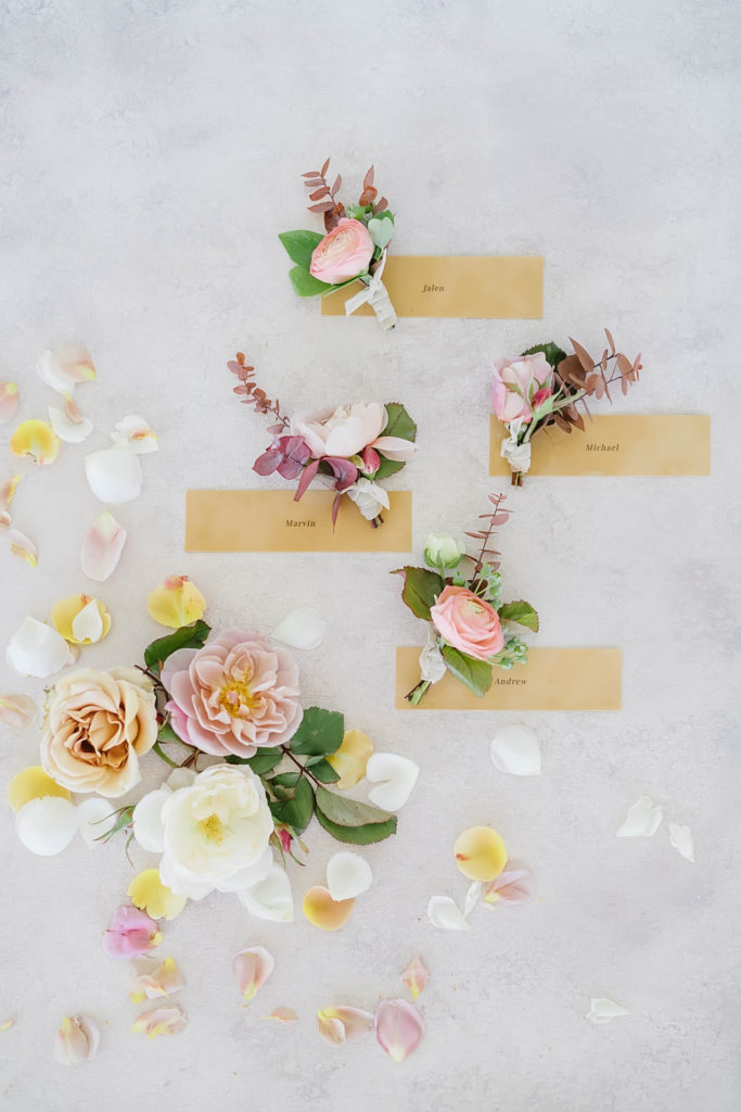 Unique pink groom boutonnière flatlay styled with white and blush flowers by Jackie Trejo Floral Design.