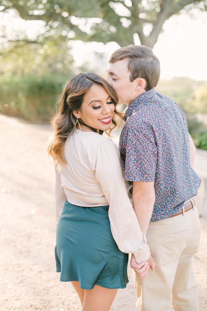Sweet kisses for the future bride during this Houston, Texas engagement session with Christina Elliot Photography. Future bride gold earrings jewelry white blouse printed button up shirt kisses love engaged couple Montgomery texas photographer engagement #christinaelliotphotography #houstonweddingphotographer #engagementpics #houstonphotographer #engagementphotos #shesaidyes #texasphotographer #photoinspiration #weddingphotography #houstonphotographer