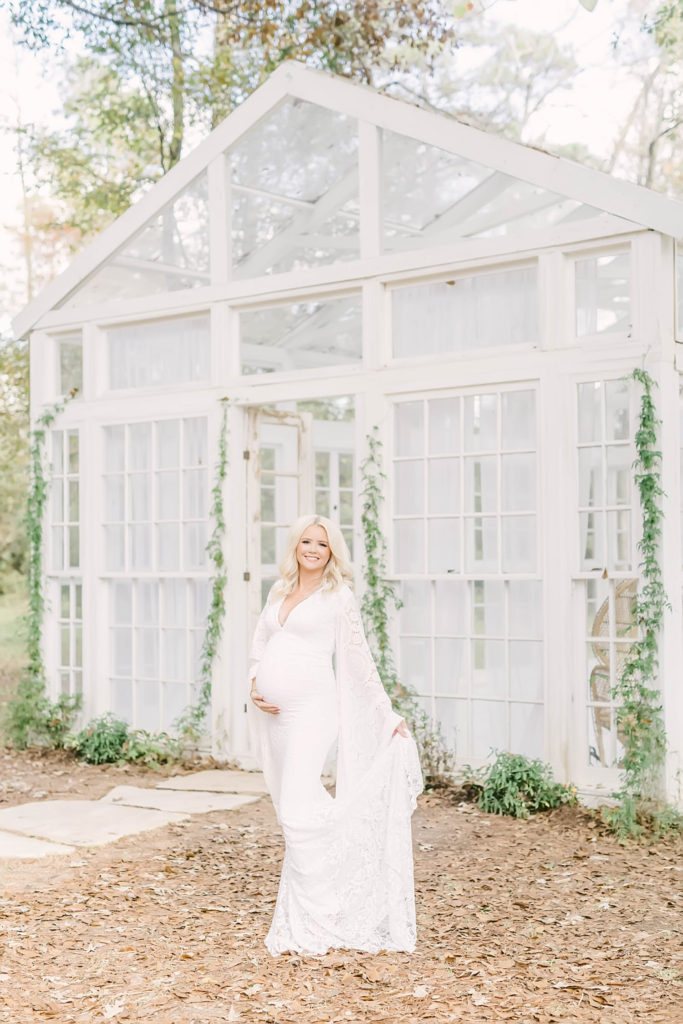 Christina Elliott Photography captures a stunning mother to be holding her baby bump in front of a window pane building in the woods in Texas. pregnancy journal maternity pose ideas maternity dress #christinaelliottphotography #christinaelliotmaternitysession #babybump #houstonmaternityphotographer #houstonmaternity #pregnancypic #houstonphotographylocations #materntiyoutfit #soontobeparents #babyontheway #houstonphotos #houstontexasmaternityphotographer #oakatelierphotos #conroetexas