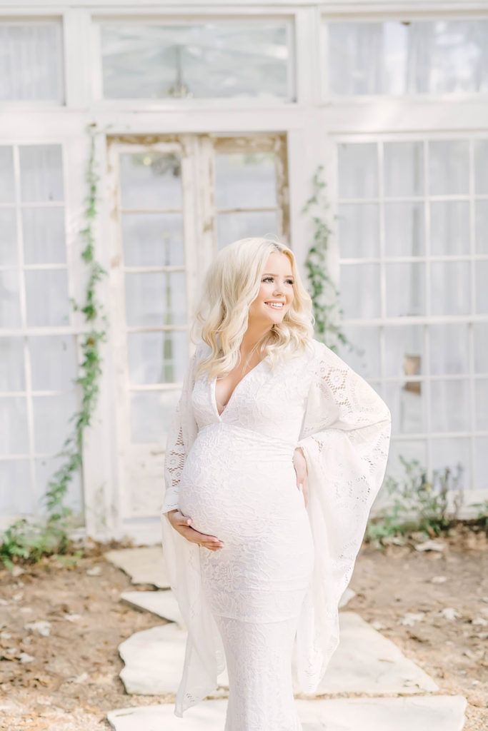 Southern belle style maternity shoot featuring a mother smiling in a white lace dress by Christina Elliott Photography at Oak Atelier. southern bell pregnancy texas mother #christinaelliottphotography #christinaelliotmaternitysession #babybump #houstonmaternityphotographer #houstonmaternity #pregnancypic #houstonphotographylocations #materntiyoutfit #soontobeparents #babyontheway #houstonphotos #houstontexasmaternityphotographer #oakatelierphotos #conroetexas