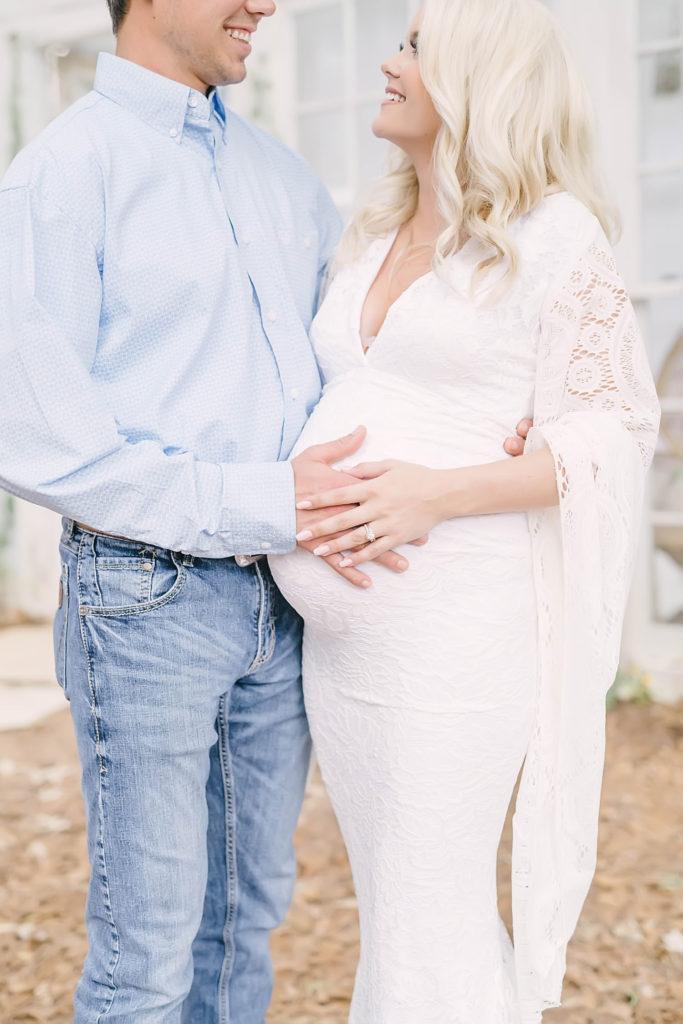 Close up of couple holding hands on top of a pregnent belly in Houston Area Maternity Session with Christina Elliott Photography. bump close-up shot zoom in bump parent goals #christinaelliottphotography #christinaelliotmaternitysession #babybump #houstonmaternityphotographer #houstonmaternity #pregnancypic #houstonphotographylocations #materntiyoutfit #soontobeparents #babyontheway #houstonphotos #houstontexasmaternityphotographer #oakatelierphotos #conroetexas