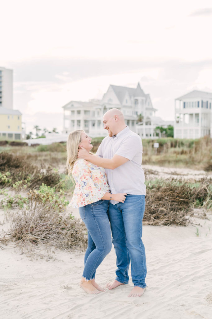 Couple poses on the beach in Galveston for engagement portraits with Christina Elliott Photography.