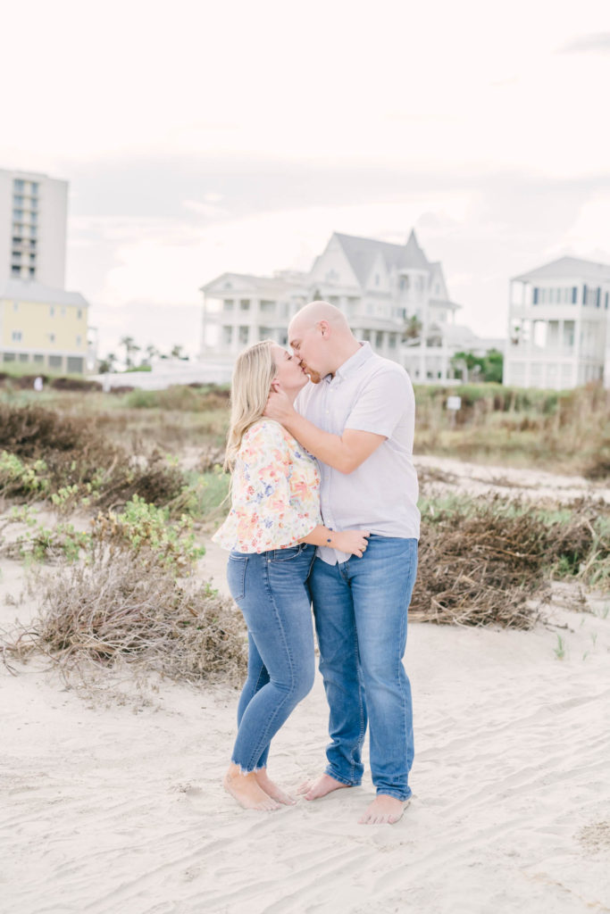 Couple lovingly kiss during their Galveston beach engagement portrait session with Christina Elliott Photography.