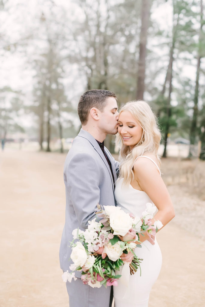 Bride and groom smile during couples portraits after their winter elopement ceremony at Memorial Park Eastern Glades with Christina Elliott Photography. Romantic bridal bouquet crafted by Blush Floral Co.