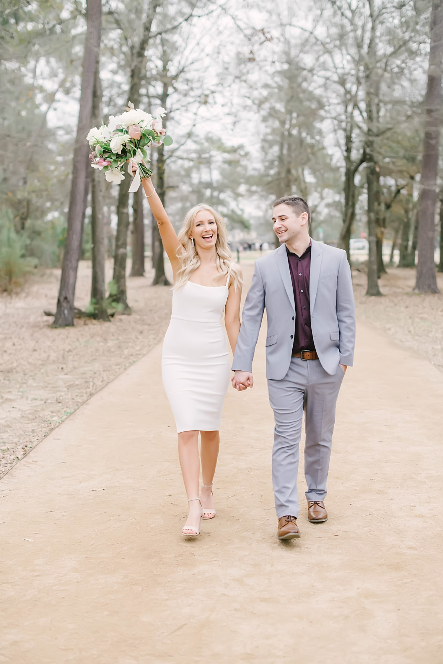 Bride and groom smile during couples portraits after their winter elopement ceremony at Memorial Park Eastern Glades with Christina Elliott Photography. Romantic bridal bouquet crafted by Blush Floral Co.