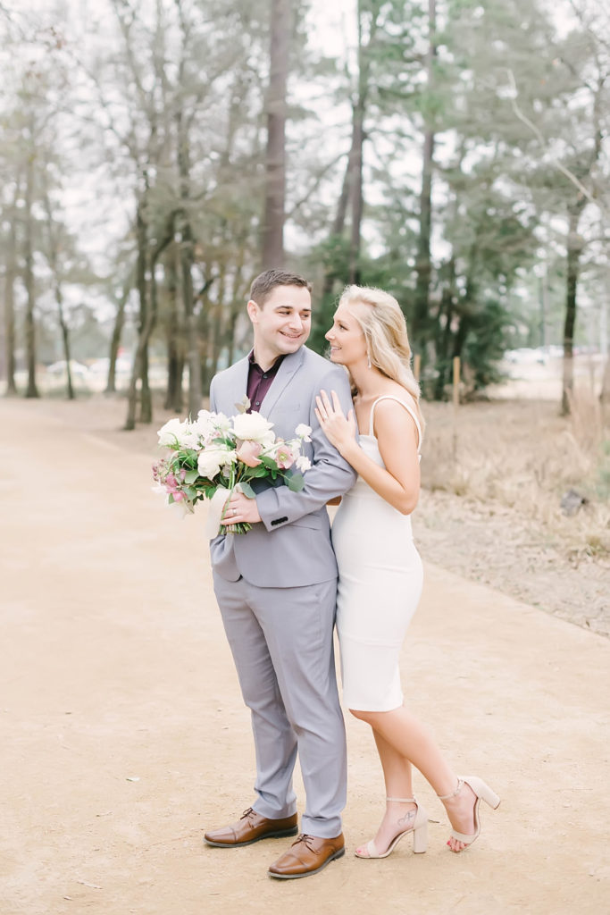 Bride and groom smile during couples portraits after their winter elopement ceremony at Memorial Park Eastern Glades with Christina Elliott Photography. Romantic bridal bouquet crafted by Blush Floral Co.