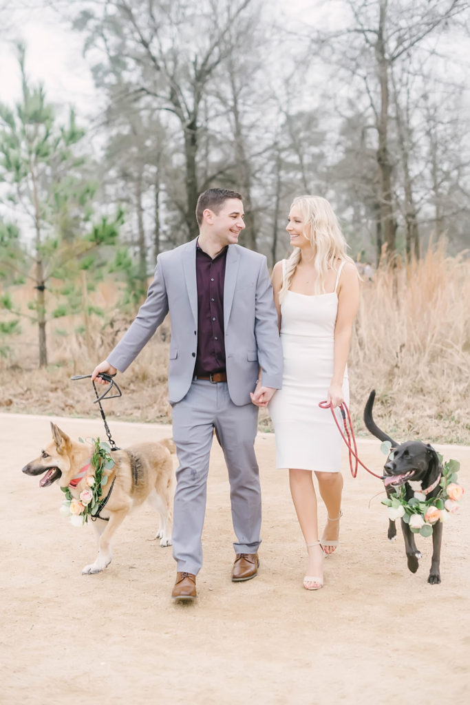 Couple pose with their dogs after their intimate wedding ceremony at Memorial Park in Houston, TX with Christina Elliott Photography. Dogs have on floral collars to celebrate.