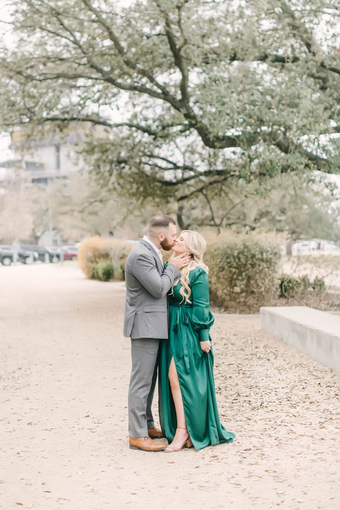 Eleanor Tinsley Park engagement photos with Christina Elliott Photography in downtown Houston wearing a green maxi dress and a gray suit. Still Waters Ranch Wedding Venue.
