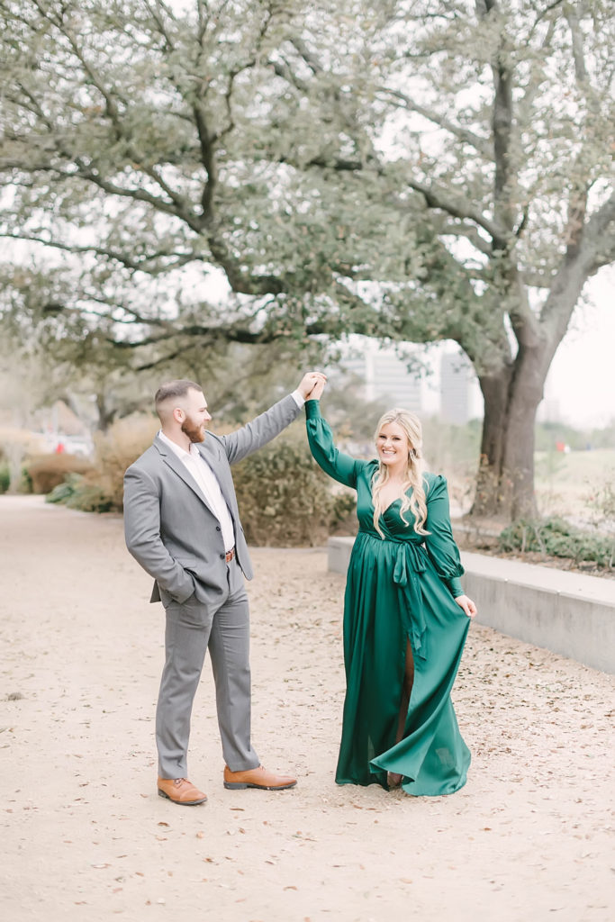 Groom spins his bride to be around at Eleanor Tinsley Park engagement photos with Christina Elliott Photography near downtown Houston.