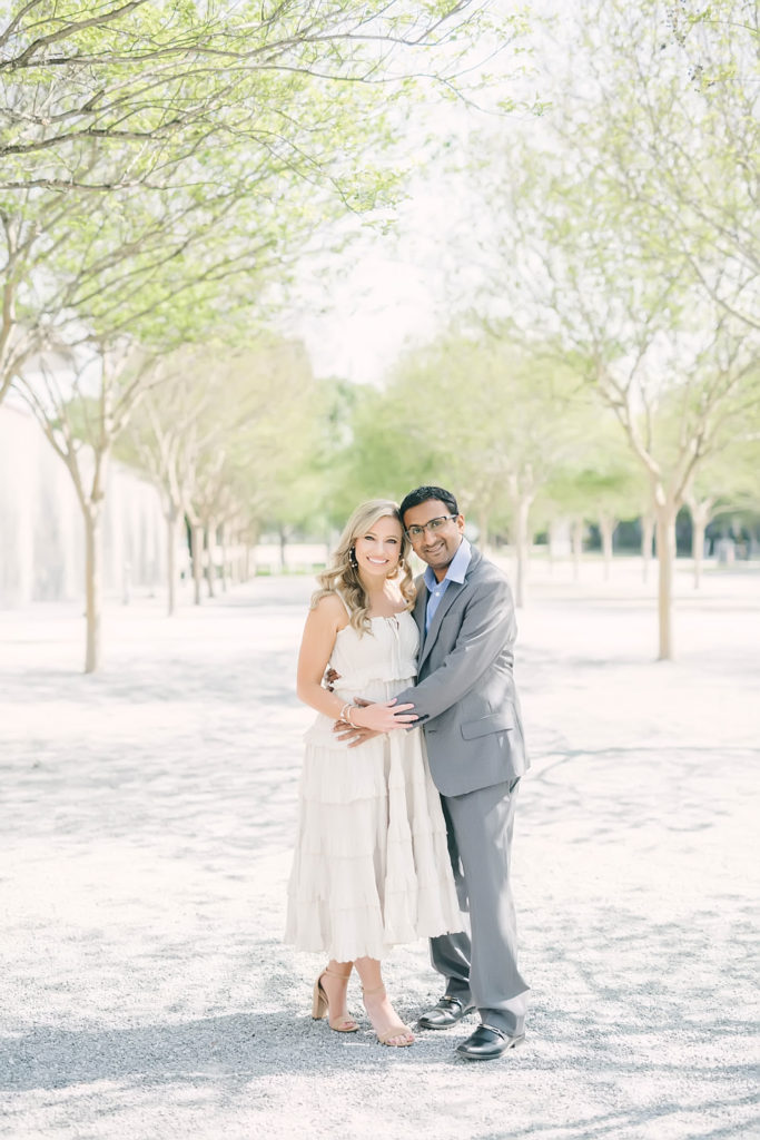 Couple snuggles in and smiles for engagement portraits at McGovern Centennial Gardens in the Houston Medical Center.