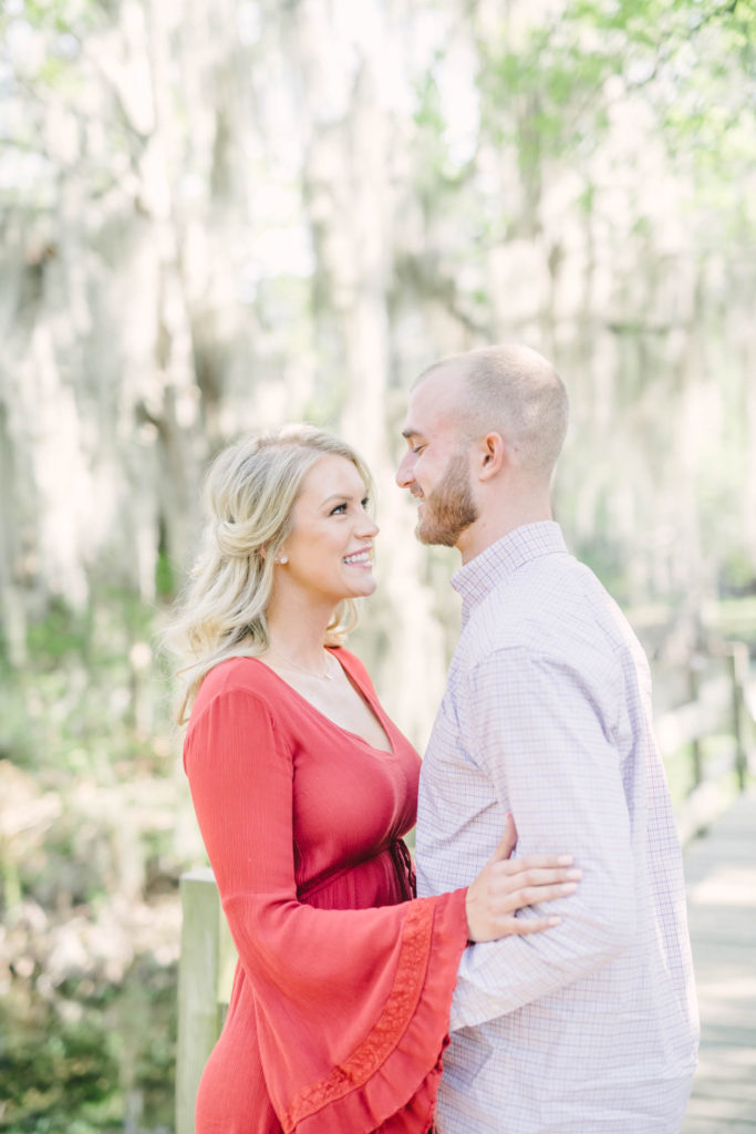 Couple smile at each other during their Houston engagement portrait session with Christina Elliott Photography for their fall wedding at The Carriage House.