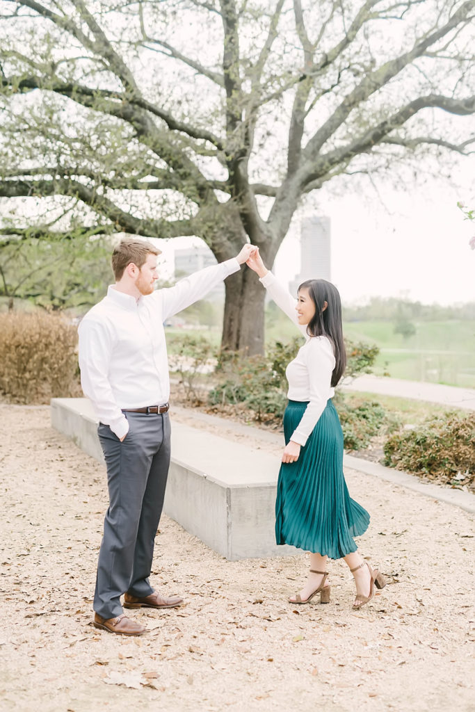 Couple dance at Eleanor Tinsley Park for their downtown Houston engagement photos.