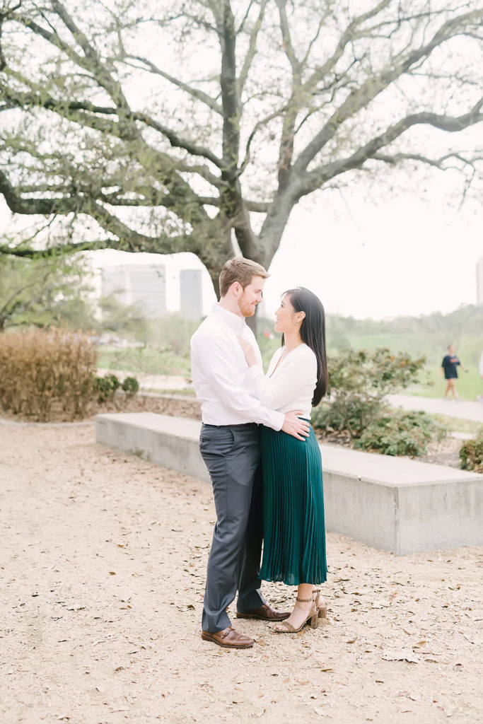 Engaged couple gaze up at each other during their Downtown Houston engagement session for their winter wedding at the Sam Houston Hotel.