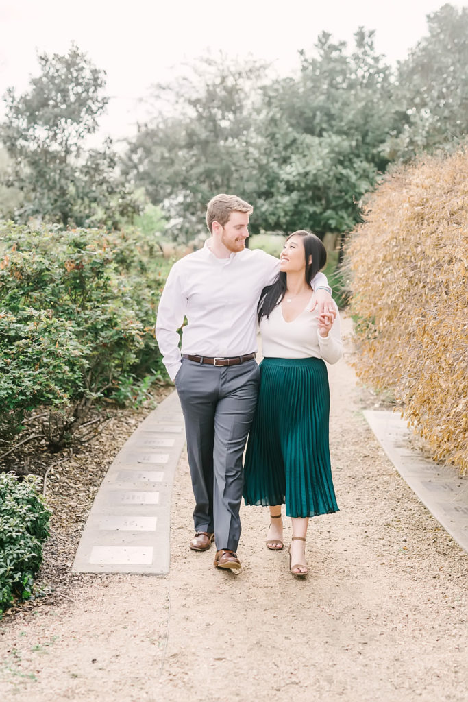 Couple strolls through the garden at Eleanor Tinsley Park during their Downtown Houston engagement session with Houston photographer Christina Elliott Photography.