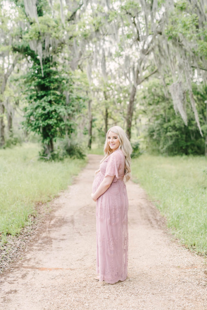 Pregnant mother-to-be holds her baby bump wearing a blush pink lace maternity gown by Houston Maternity Photographer Christina Elliott Photography. mauve pregnancy gown pregnancy journal picture #christinaeliottphotography #christinaelliotmaternity #brazosbendstatepark #houstonmaternityphotographer #parentstobe #babybumpicutes #houstonareaphotographer #professionalmaternityphotographer #houstonmaternity #preggo #pregnancyjournal #texasmaternityphotographer