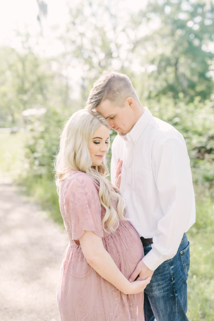 The couple presses their foreheads together and pose during their light and an airy maternity portrait session at Brazos Bend State Park by Christina Elliott Photography. snuggle pose dreaming of the future awaiting a baby #christinaeliottphotography #christinaelliotmaternity #brazosbendstatepark #houstonmaternityphotographer #parentstobe #babybumpicutes #houstonareaphotographer #professionalmaternityphotographer #houstonmaternity #preggo #pregnancyjournal #texasmaternityphotographer