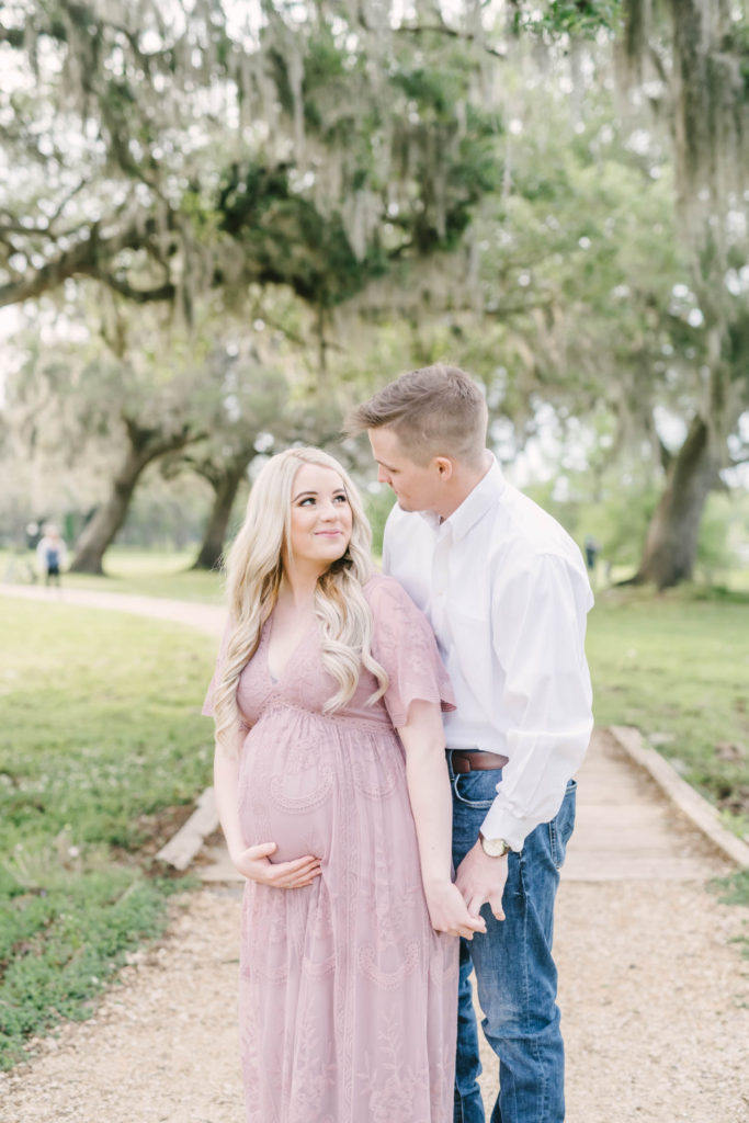 Woman with long blonde hair holds her baby bump and looks lovingly up at her cowboy husband at Brazos Bend State Park by Christina Elliott Photography. long hair styles for pictures baby girl on the way baby girl #christinaelliotmaternity #brazosbendstatepark #houstonmaternityphotographer #parentstobe #babybumppicutes #houstonareaphotographer #professionalmaternityphotographer #houstonmaternity #preggo #pregnancyjournal #texasmaternityphotographer