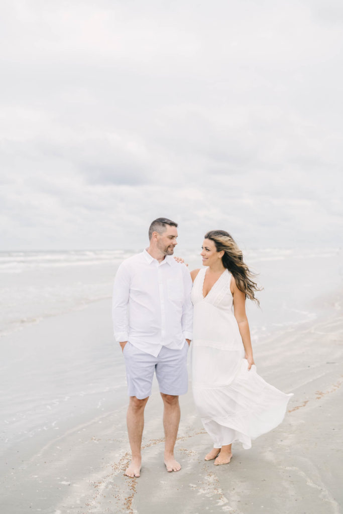 Cloudy beach engagement session in white flowing dress with Galveston wedding photographer Christina Elliott Photography.