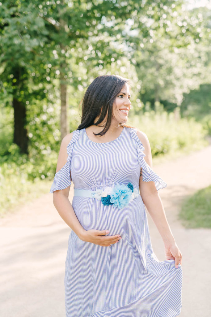 Christina Elliot Photography in Texas photographs a baby bump with a blue ribbon around the belly to show the gender of the baby. blue ribbon for gender reveal. most flattering outfit for maternity how to dress your bump purple dress summer color for photoshoot how to do your hair for maternity session texas maternity photographer bump outfits #maternityphotos #maternityphotoshoot #maternityphotographers #texasmaternityphotographers #outfitinspoformaternityphotoshoot