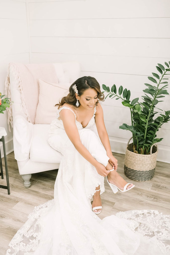 Beautiful bride getting ready for wedding putting on classic sling-back shoes for the big day in Texas by Christina Elliot Photography. wedding day how to dress sweetheart dress hair inspo for wedding farmhouse wedding how to dress as the bride white dresses for wedding getting ready photos for wedding texas wedding photographer how to plan your wedding texas wedding locations #texasweddingphotographer #farmhousewedding #farmhouseweddinginspo #texasphotographer #farmhouseweddingdecor #texasweddinglocations