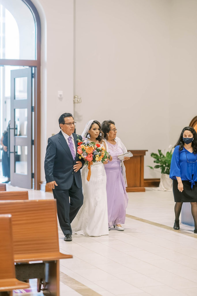 Perfect bride walking down the aisle with her parents wearing purple as a summer wedding color by Christina Elliot Photography in Texas. wedding decor inspo purple wedding colors walking down the altar colors for mother of the bride the best church to marry in tecas church wedding farmhouse wedding decor white flowers for wedding #texasweddingphotographer #farmhousewedding #farmhouseweddinginspo #texasphotographer #farmhouseweddingdecor #texasweddinglocations