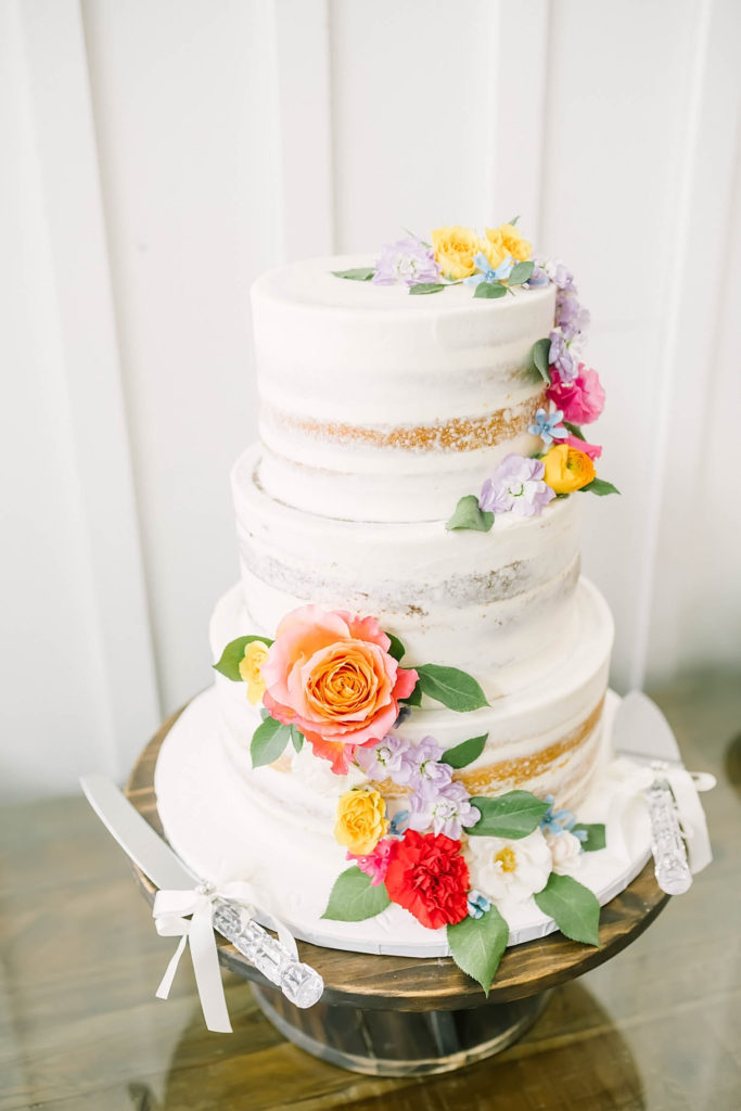 Summer farmhouse wedding in Texas by Christina Elliot Photography with naked wedding cake with red and yellow and orange flowers. red and yellow wedding colors summer wedding colors table decor for wedding how to decorate for summer wedding the best wedding colors cake inspo for wedding ideas for wedding cake naked wedding cake #texasweddingphotographer #farmhousewedding #farmhouseweddinginspo #texasphotographer #farmhouseweddingdecor #texasweddinglocations