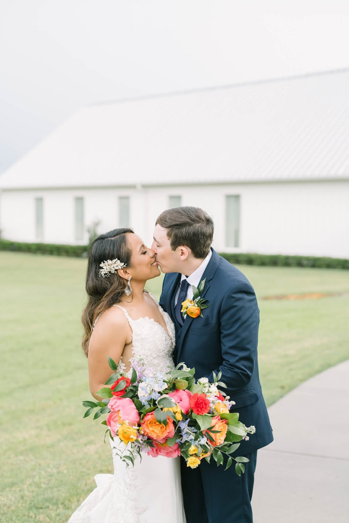 Perfect bride and groom kissing during a perfect summer farmhouse wedding in Texas by Christina Elliot Photography. poses for bride and groom farmhouse wedding how to dress for a summer wedding outfits for bride and groom poses for bride and groom classic wedding dress for bride classic suit for groom summer outfits for wedding white barn wedding #texasweddingphotographer #farmhousewedding #farmhouseweddinginspo #texasphotographer #farmhouseweddingdecor #texasweddinglocations