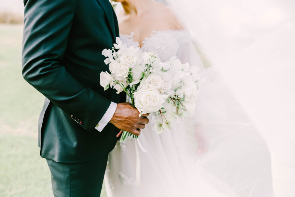 Wedding photographer Christina Elliott Photography captures a stunning shot of groom in black suit holding bouquet and bride with sweetheart neckline in Houston. professional Houston wedding photography high-end wedding photography #christinaelliottphotography #christinaelliottweddings #TheFarmhouseMontgomery #farmhouseweddings #texasweddings #houstonweddingphotographers #mrandmrs #tildeathdowepart #weddingphotography #tietheknot #Houstonweddings #weddinginspiration #bride #groom