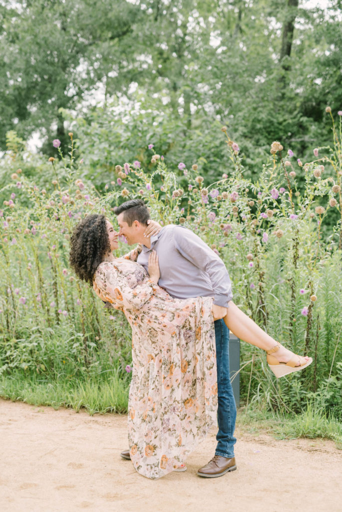 Husband dips his wife as he holds onto her leg and goes in for a kiss in front of purple wildflowers in Houston, Texas with Christina Elliott Photography. husband and wife pose dip kiss pose couple portrait mother and father #christinaelliottphotography #christinaelliottfamilies #houstonfamilyphotographer #familyofthree #Houstonarboretum #babyboy #familypictures #outdoorfamilypictures #summerfamilypics #familyphotos #famiyphotographer #Houstonfamilyphotos