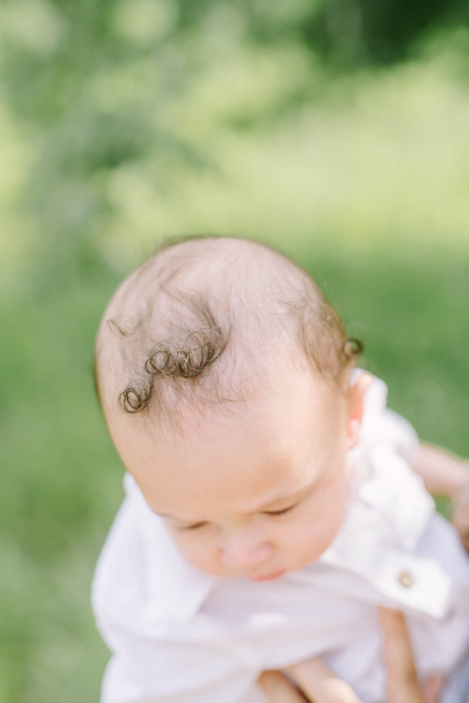 Christina Elliott Photography a Houston family photographer captures the top of a baby's head with dark brown curly hair. curly baby boy hair sweet child of mine baby boy photography toddlers during family pictures #christinaelliottphotography #christinaelliottfamilies #houstonfamilyphotographer #familyofthree #Houstonarboretum #babyboy #familypictures #outdoorfamilypictures #summerfamilypics #familyphotos #famiyphotographer #Houstonfamilyphotos