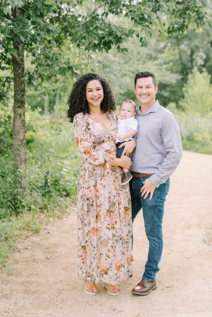 A family of three smiles for a family portrait outside during the summertime in Houston by family photographer Christina Elliott Photography. Houston family photography outdoor family photo locations in Houston family of three portrait #christinaelliottphotography #christinaelliottfamilies #houstonfamilyphotographer #familyofthree #Houstonarboretum #babyboy #familypictures #outdoorfamilypictures #summerfamilypics #familyphotos #famiyphotographer #Houstonfamilyphotos